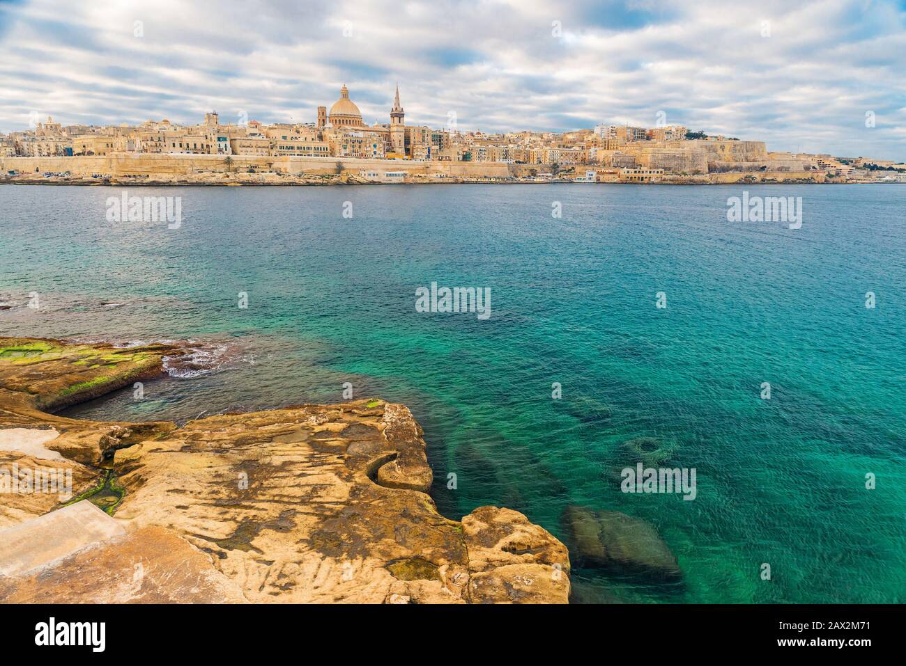 Splendida vista sulla Valletta, lo skyline della città vecchia di Malta dalla città di Sliema sull'altro lato del porto di Marsans all'alba Foto Stock