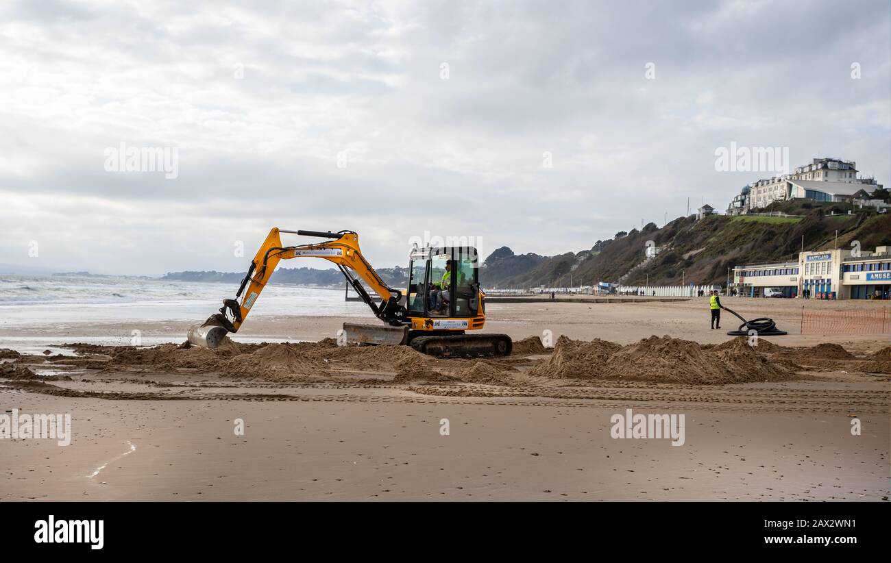 Escavatore JCB scavando la spiaggia a Bournemouth, Dorset, Regno Unito, il 7 febbraio 2020 Foto Stock
