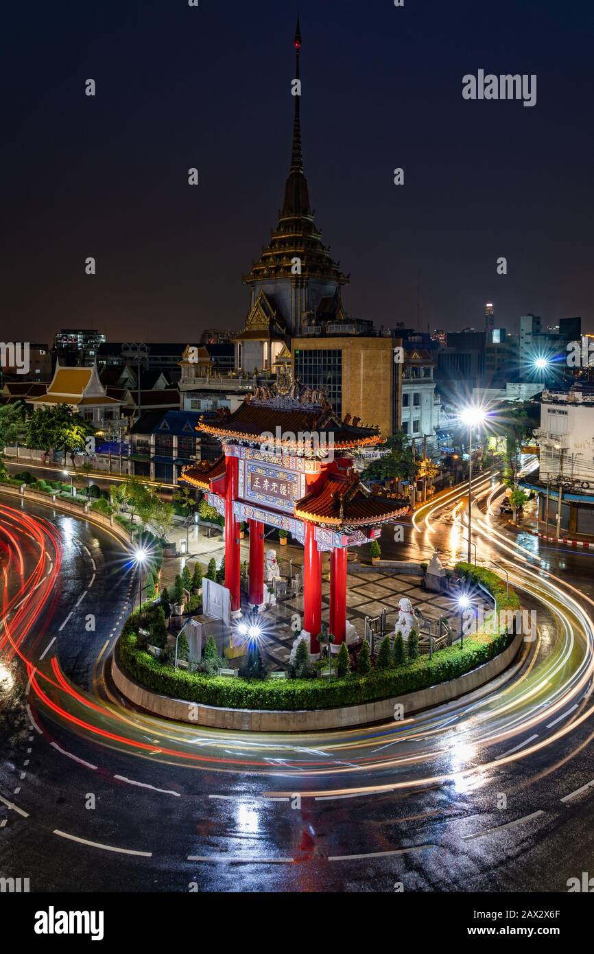 Vista notturna del traffico attorno all'Odeon Circle che mostra il punto di riferimento architettonico di Chinatown Gate a Bangkok, Thailandia. Foto Stock