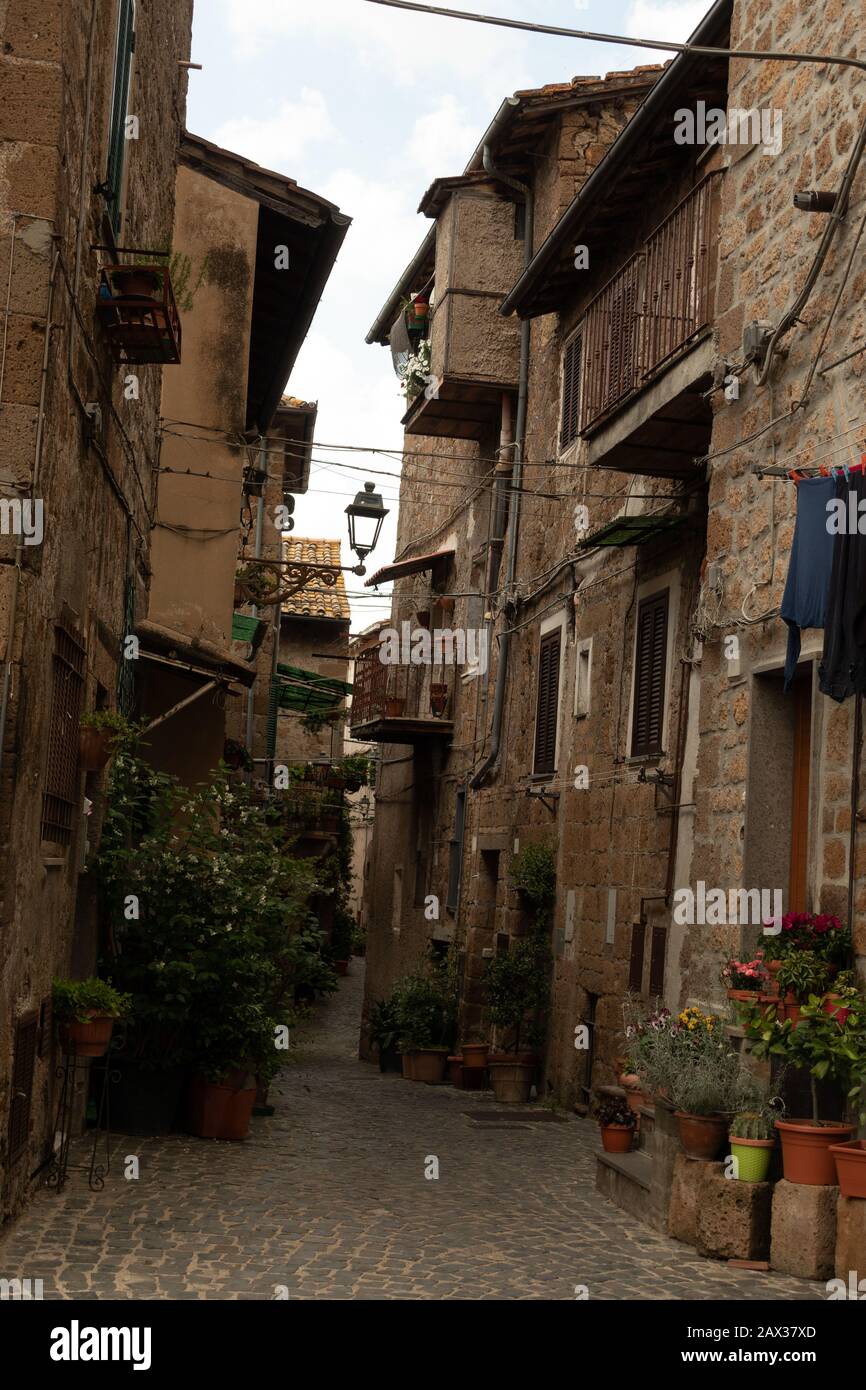 Vicolo stretto, alte vecchie case scure nel medievale Sutri Italia Foto Stock
