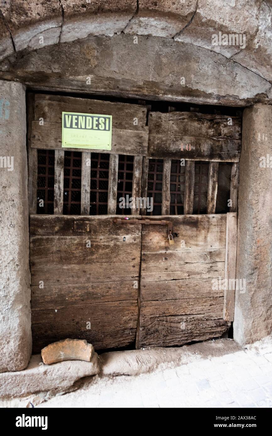 Per vendita segno su proprietà e vecchia porta in legno Vetralla Foto Stock