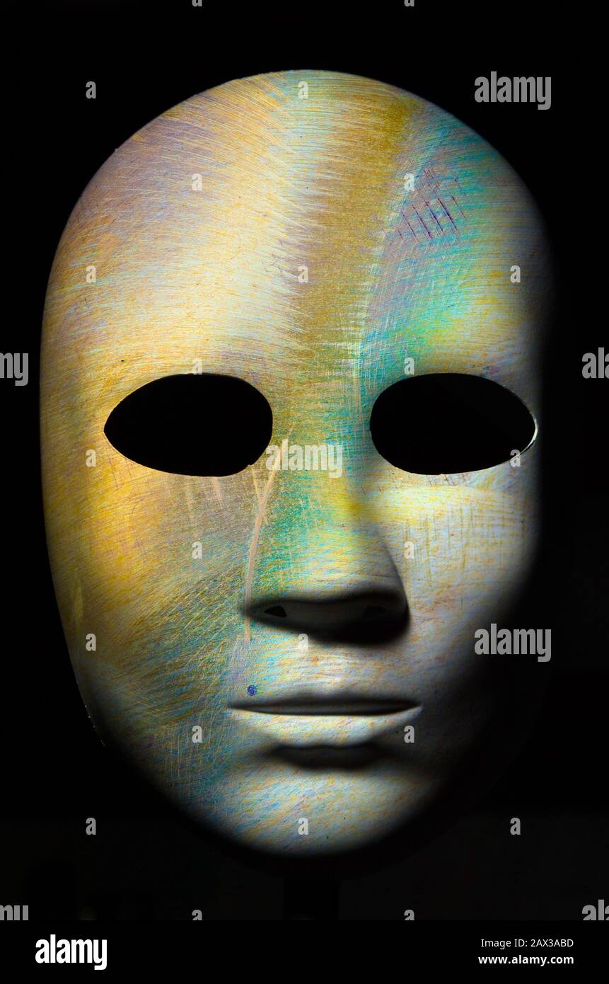 Maschera a trama con incrinato legno ruvida la superficie verniciata, espressione neutrale su sfondo scuro. Foto Stock