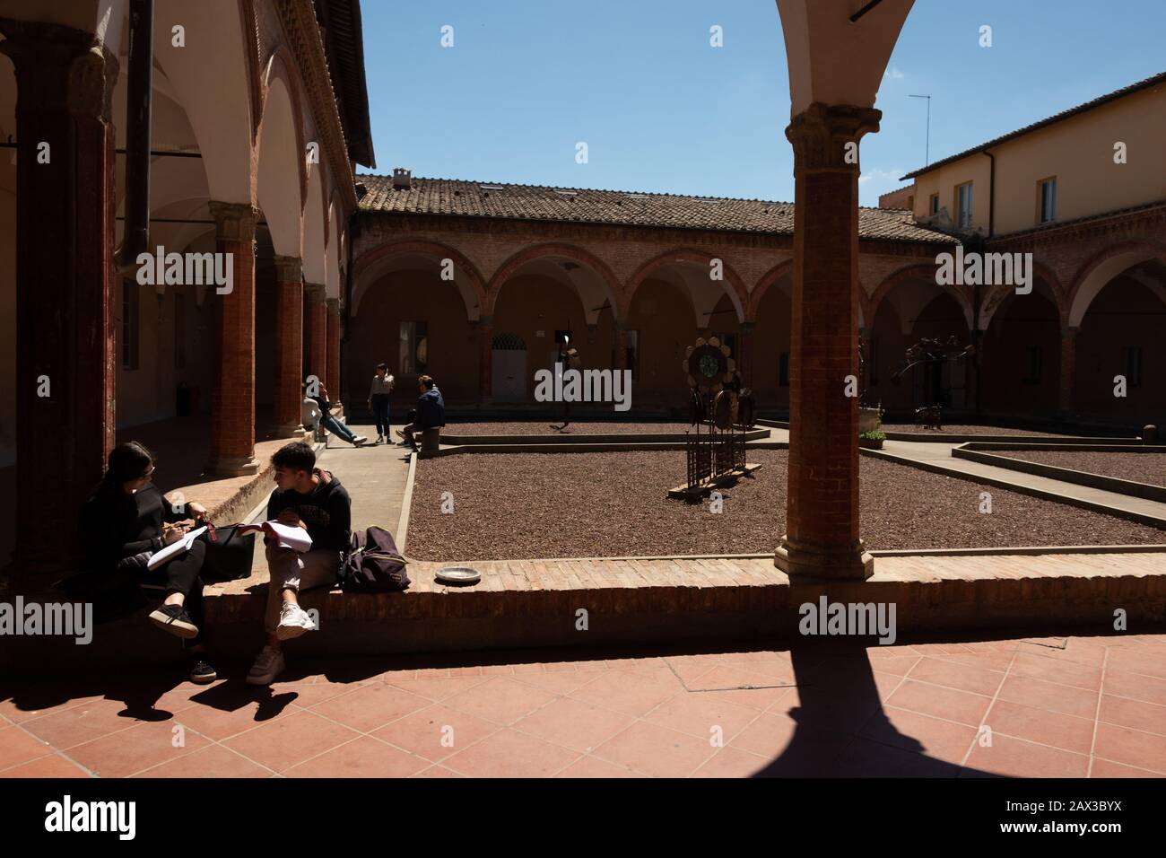 Studenti che studiano nel cortile della facoltà Richard Goodwin Università di Siena Toscana Italia Foto Stock