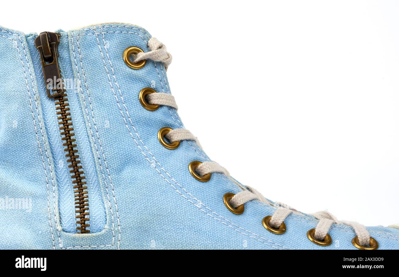 frammento di sneaker blu con lacci in tessuto bianco e chiusura zip in ferro su sfondo bianco, primo piano Foto Stock