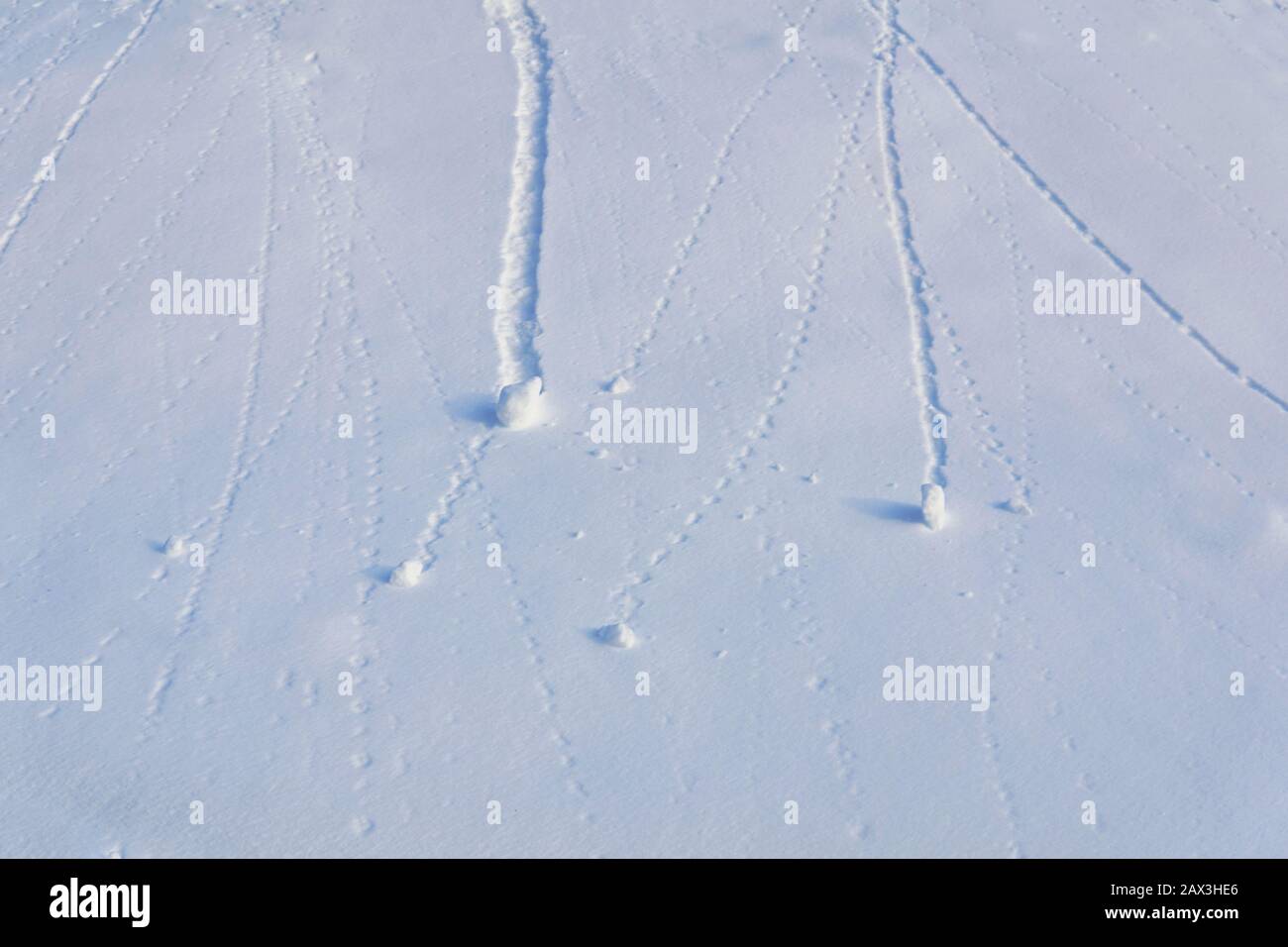 sfondo naturale - palle di neve che rotolano lungo la pista innevata ha lasciato tracce Foto Stock