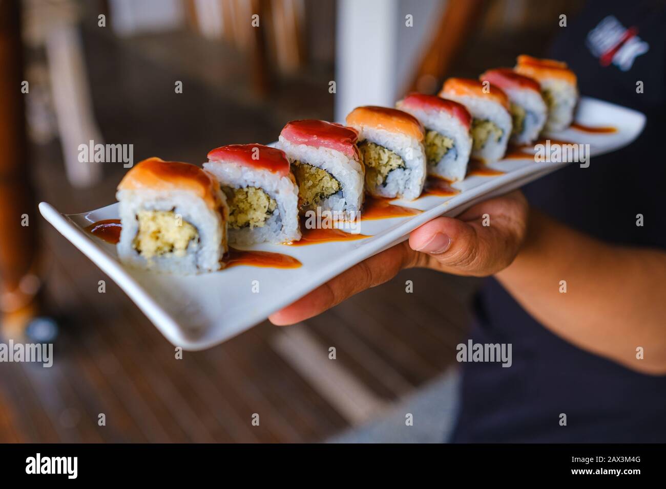 Primo piano di qualcuno che tiene un vassoio di diversi tipi di sushi Foto Stock