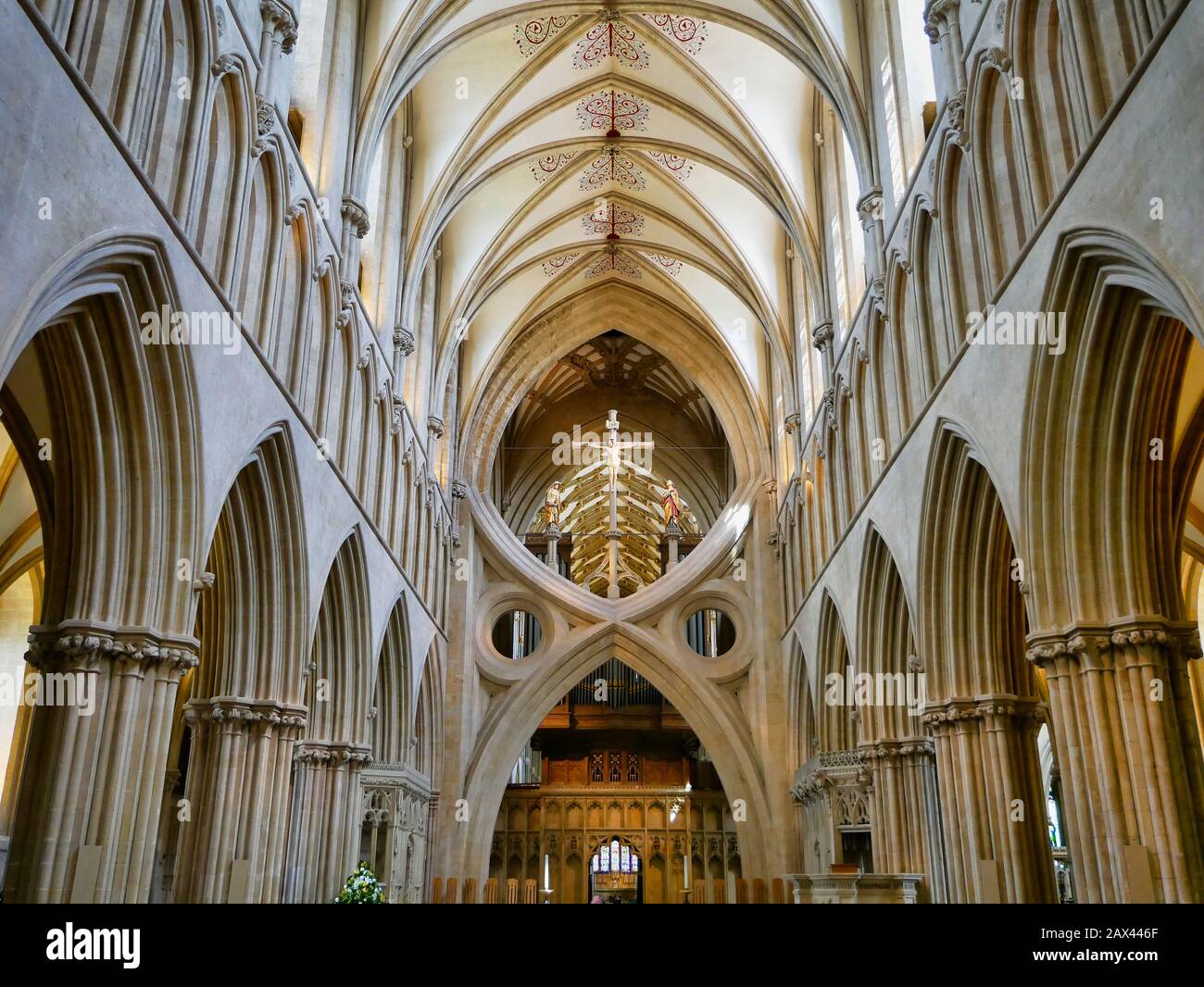 Sant'Andrea, archi a croce e crocifisso sotto la torre della Cattedrale di Wells. Gli archi della navata e la volta quadripartita del tetto sono mostrati. Foto Stock