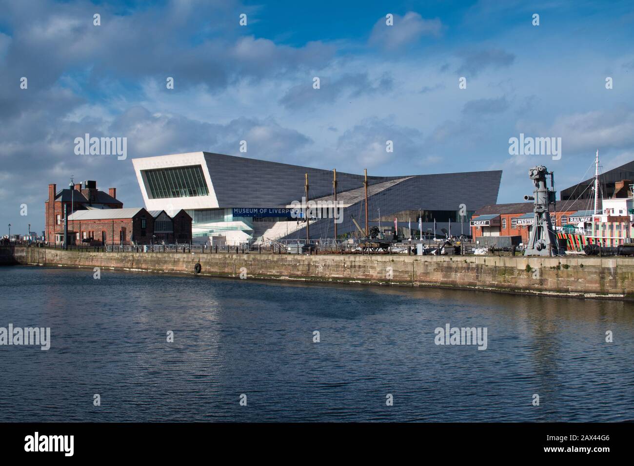 L'architettura moderna del Museo di Liverpool attraverso Canning Dock in una giornata di sole. Il Pilotage Building in mattoni rossi appare sulla sinistra. Foto Stock