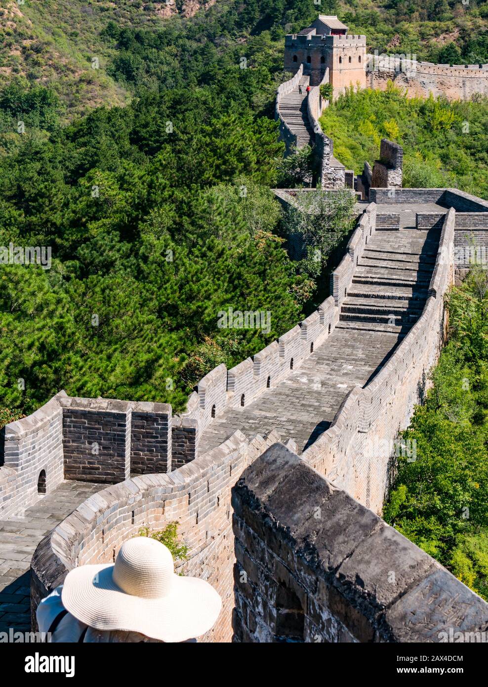 Tourist indossando cappello di paglia a brimmed largo durante la giornata calda sulla Grande Muraglia di Jinshanling della torre di guardia cinese e donna asiatica indossando un cappello a brimmed largo, Cina, Asia Foto Stock