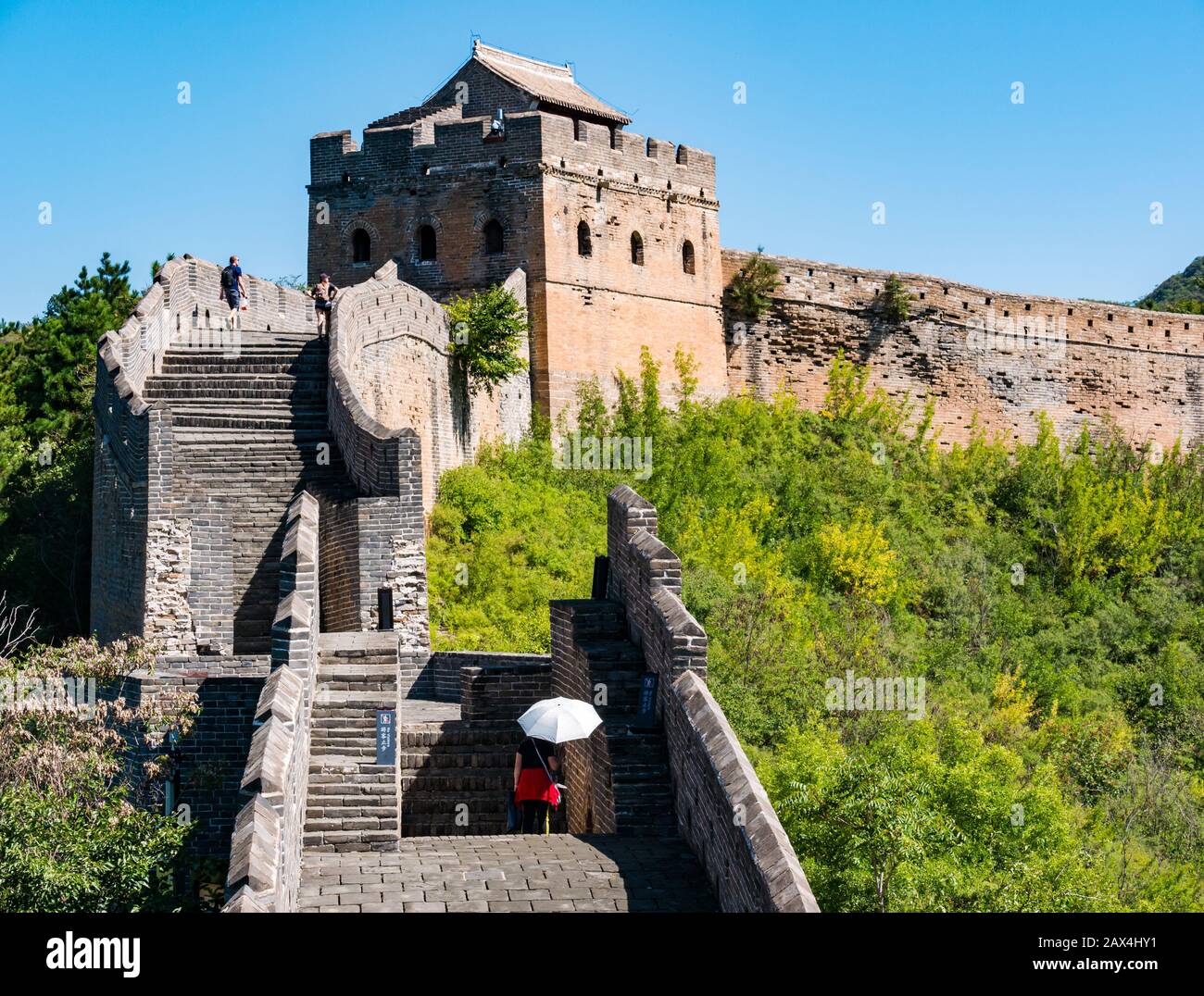 Persone che camminano sulla Grande Muraglia cinese di Jinshanling in condizioni di sole, con ombrellone, provincia di Hebei, Cina, Asia Foto Stock