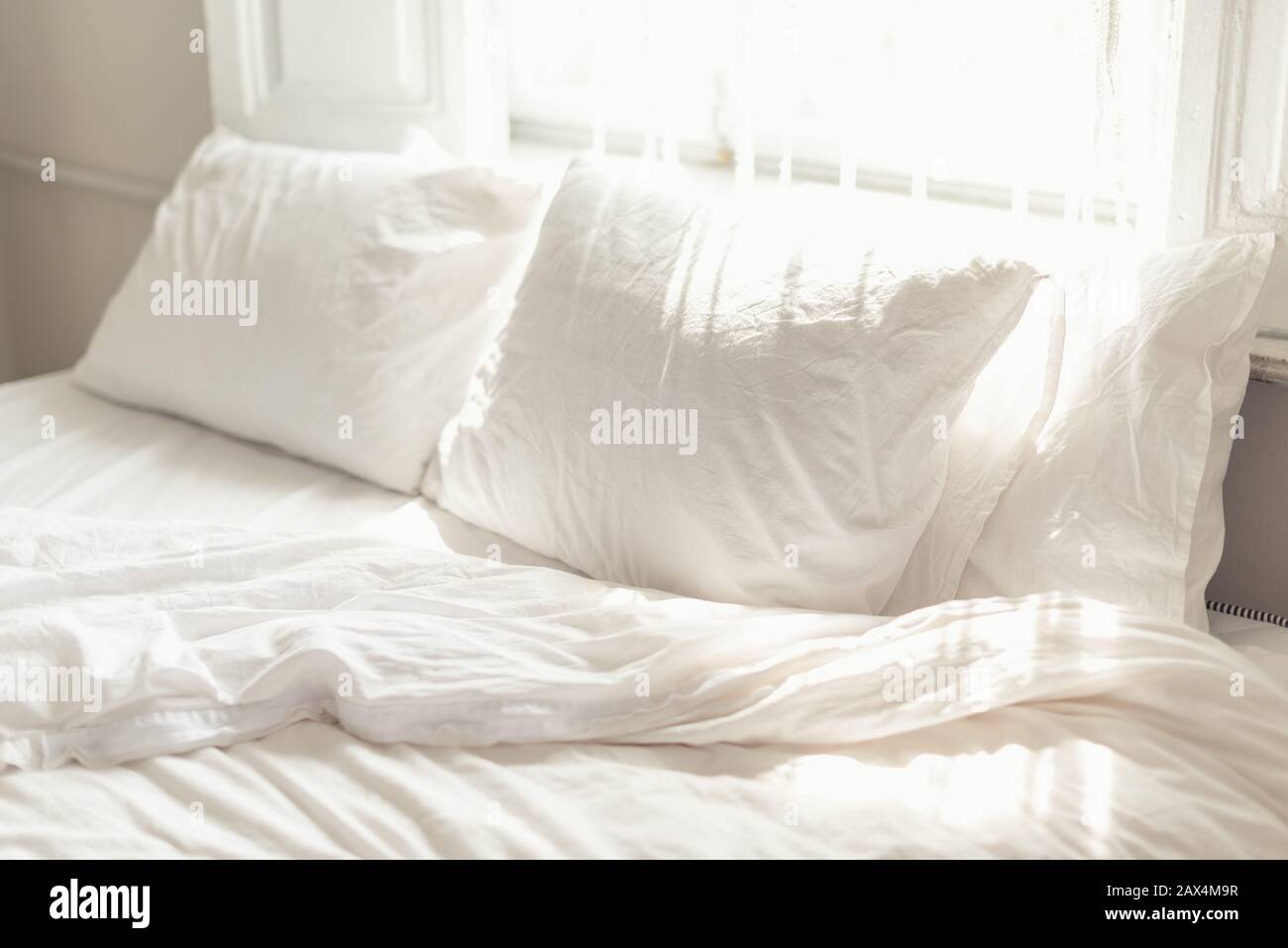Cuscino bianco e biancheria da letto in camera da letto luminosa Foto Stock