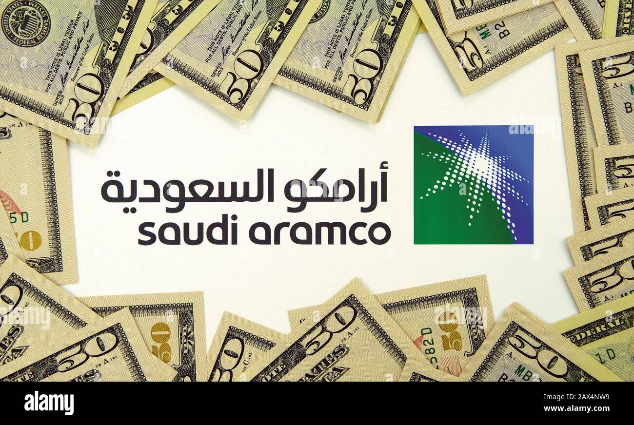 Saudi Aramco, logo circondato da banconote in dollari. Saudi Arabian Oil Company è una delle più grandi aziende del mondo per entrate. Non un montaggio. Foto Stock