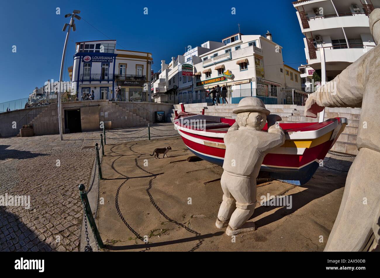 Barca in legno a statue a Fishermens Beach. Albufeira, Algarve, Potugal Foto Stock