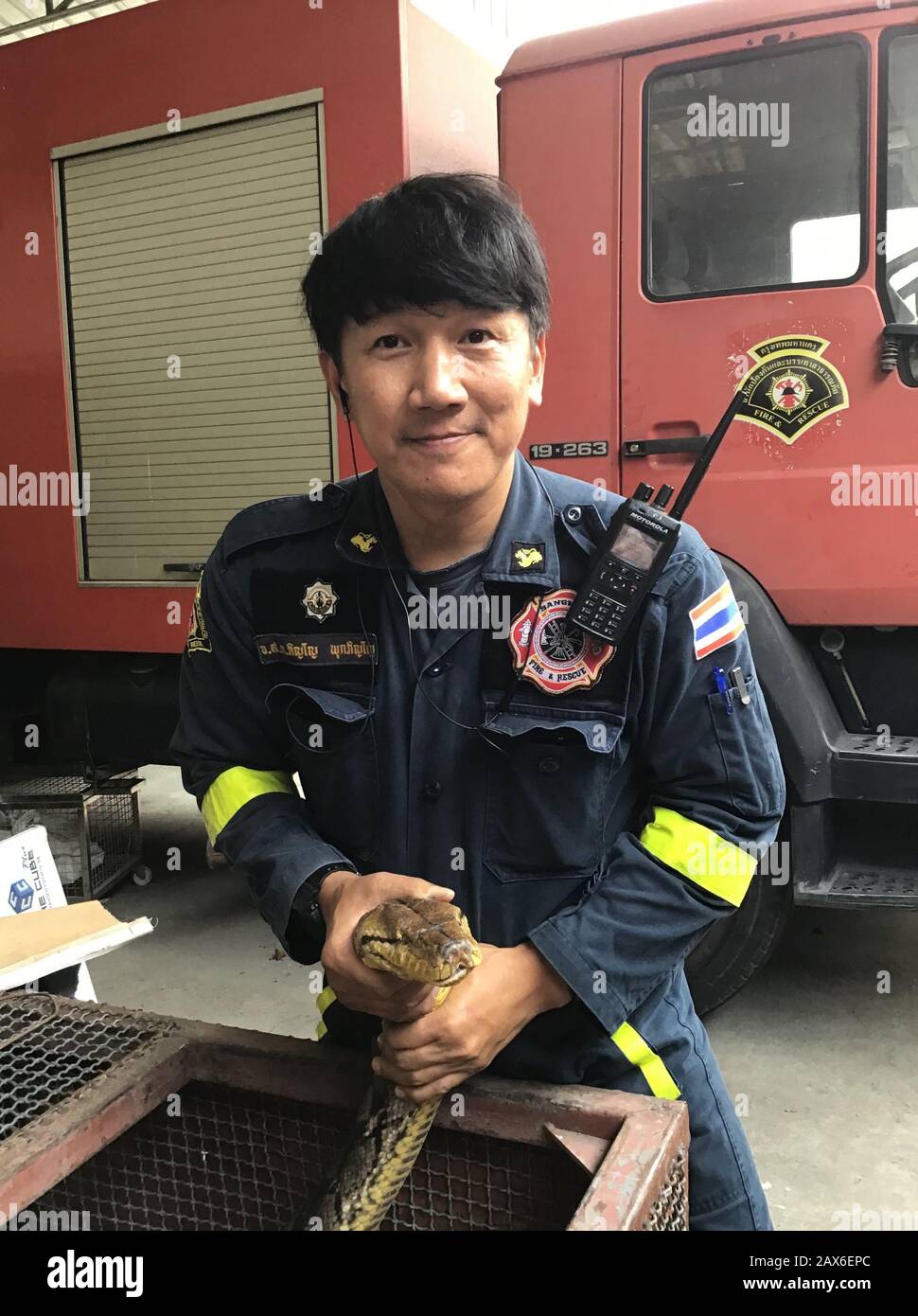 Bangkok, Tailandia. 03rd Feb, 2020. Pinyo Pukpinyo, cacciatore di serpenti presso il reparto antincendio. Sul suo orologio mostra un pitone. Nella capitale tailandese, la brigata antincendio è chiamata più spesso per i serpenti che per spegnere gli incendi. (A dpa 'The Snake Hunter of Bangkok') credito: Caroline Bock/dpa/Alamy Live News Foto Stock