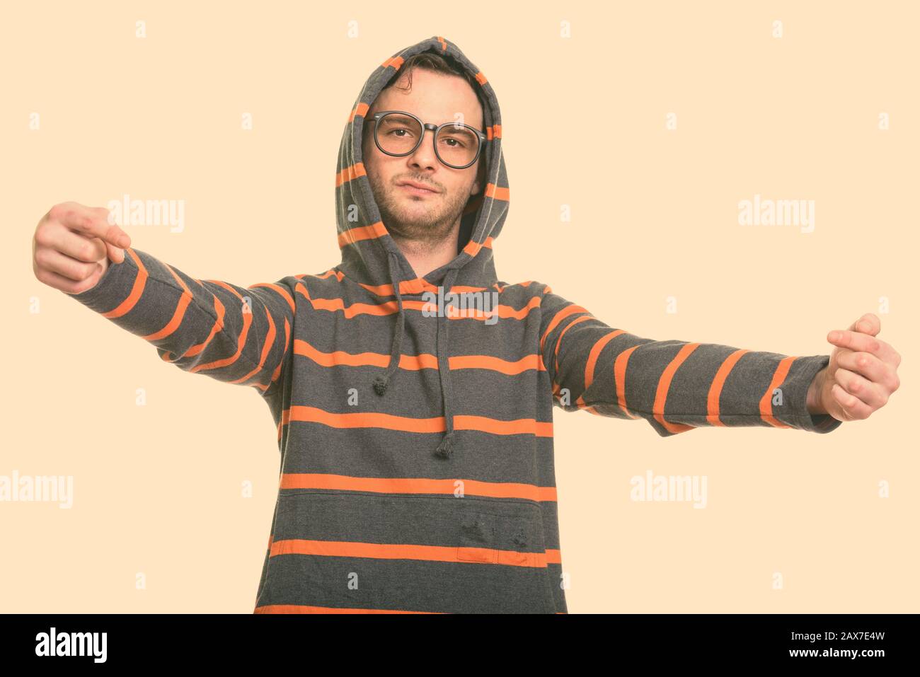 Studio shot del giovane uomo che indossa hoodie mentre puntando entrambe le dita a se stesso Foto Stock