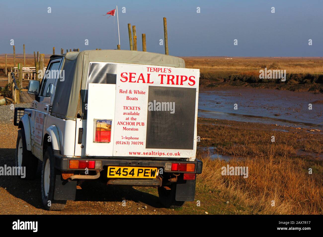 Un veicolo a 4 ruote motrici parcheggiato dalla banchina pubblicità viaggi sigillo a Blakeney Point a Morston, Norfolk, Inghilterra, Regno Unito, Europa. Foto Stock