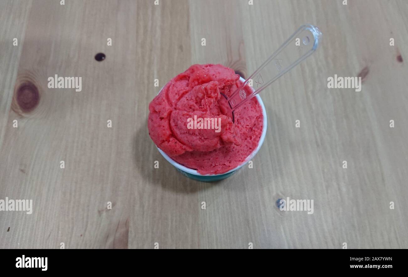 gelato alla fragola su tavolo di legno. gelato alla tazza. colore rosa Foto Stock