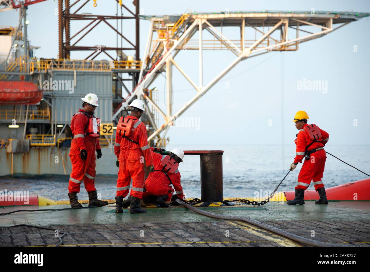 L'equipaggio marino inizia l'operazione di movimentazione dell'ancora sul ponte per il carro di sollevamento Foto Stock