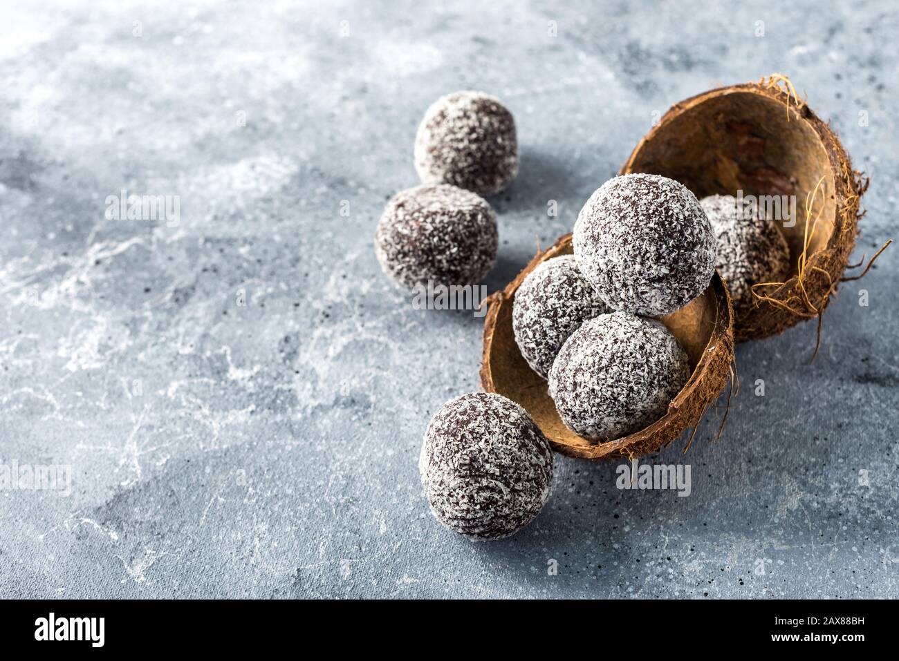 Palle di energia proteica sane fatte in casa in una ciotola di cocco con albicocche secche, uva passa, noci, mandorle e cocco. Cibo sano dolce Foto Stock