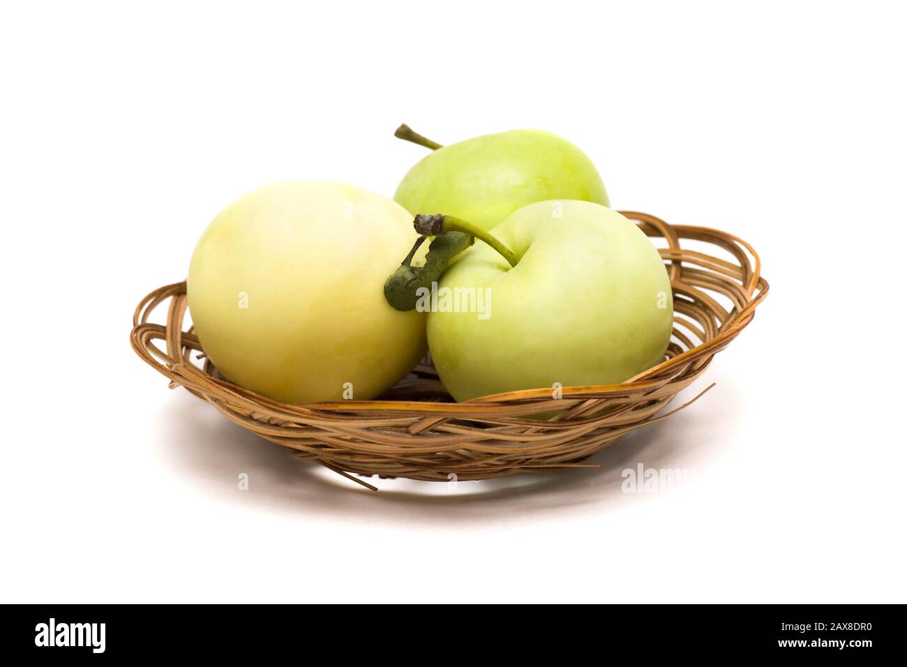 Tre mele verdi in un cestino su uno sfondo bianco Foto Stock