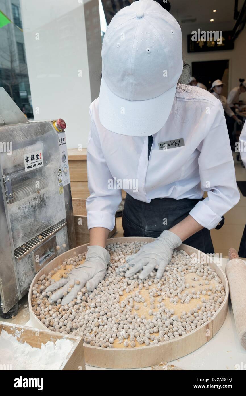 Un giovane americano asiatico fa palle di tapioca per bere una boba nella finestra di Xing fu Tang, un negozio taiwanese sulla Main St. A Flushing, Queens, Chinatown Foto Stock