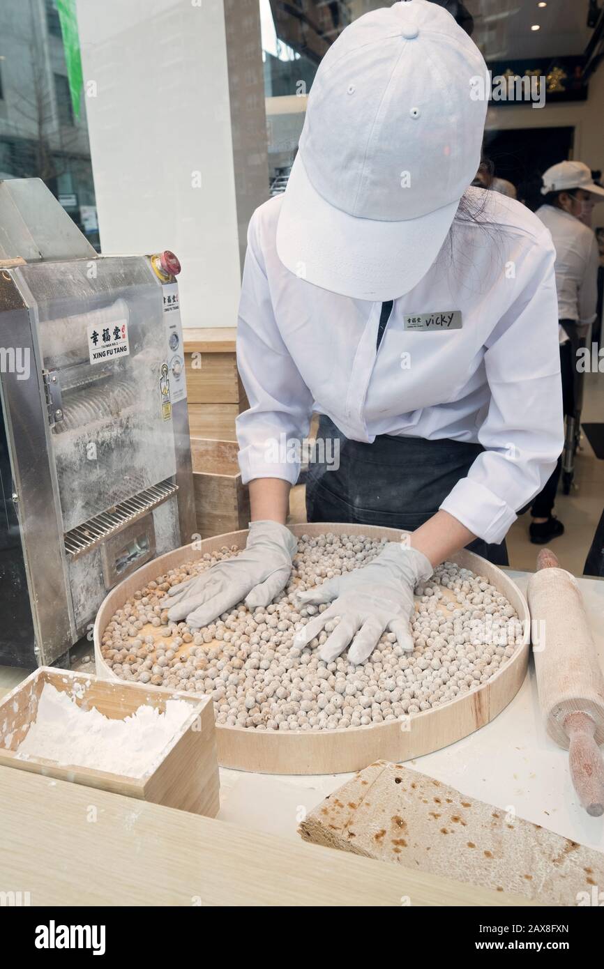 Un giovane americano asiatico fa palle di tapioca per bere una boba nella finestra di Xing fu Tang, un negozio taiwanese sulla Main St. A Flushing, Queens, Chinatown Foto Stock
