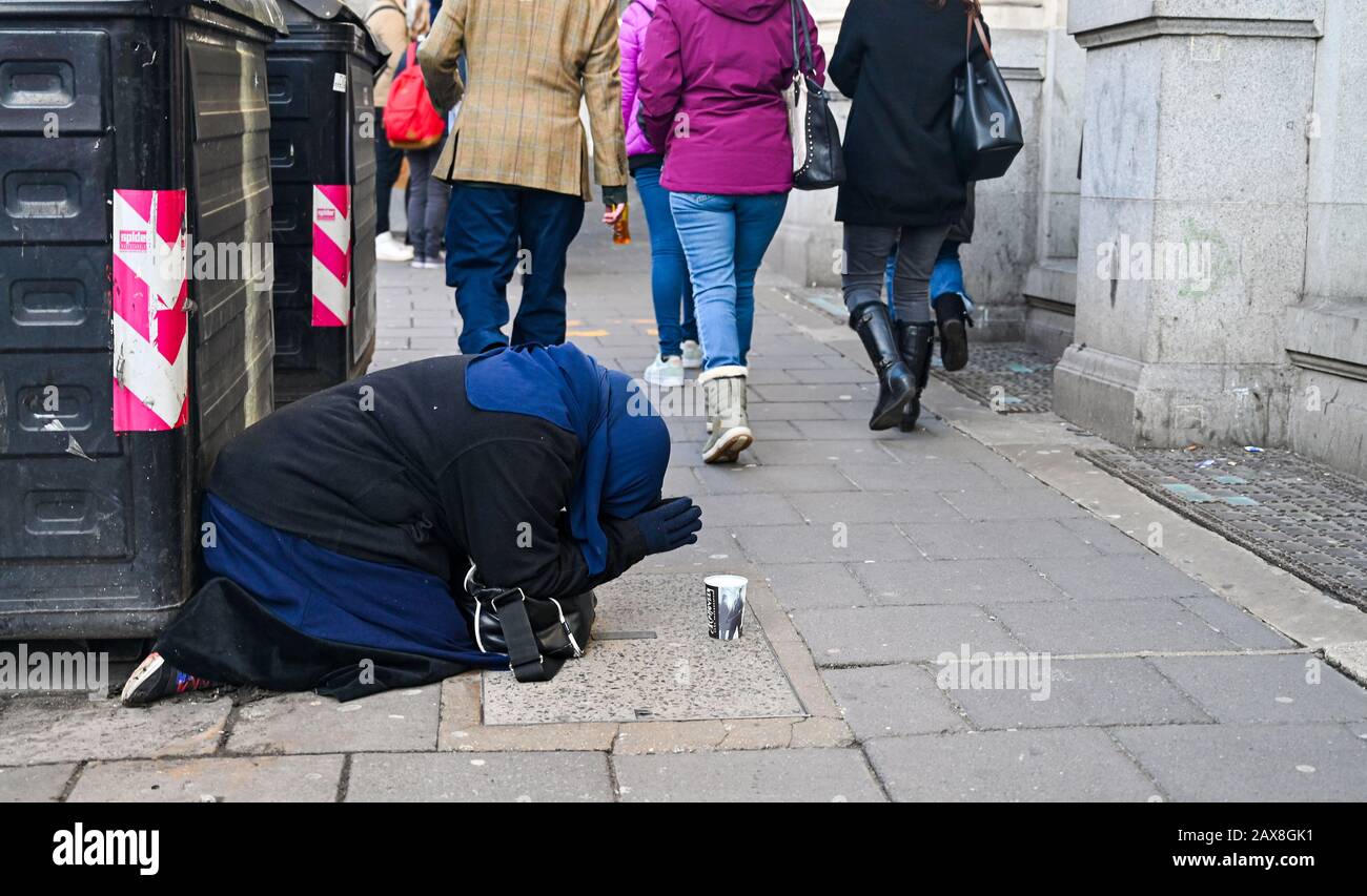 Donna che chiede a North Street Brighton mentre appare per pregare East Sussex UK Fotografia presa da Simon Dack Foto Stock