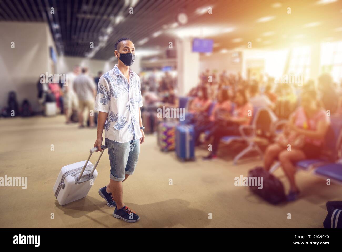 Turista asiatico con bagaglio, indossare maschera per evitare durante il viaggio al terminal dell'aeroporto per proteggere dalla nuova infezione da Coronavirus 2019 Foto Stock