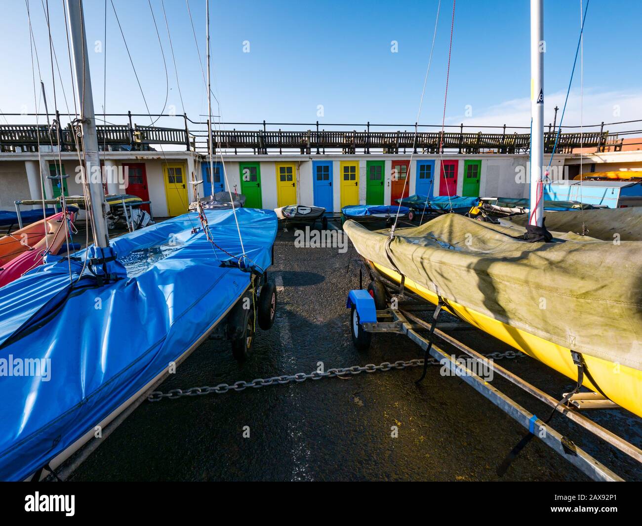 Porte colorate numerate nel cortile di deposito delle barche in inverno (ex cubicoli cambianti), porto di North Berwick, East Lothian, Scozia, Regno Unito Foto Stock