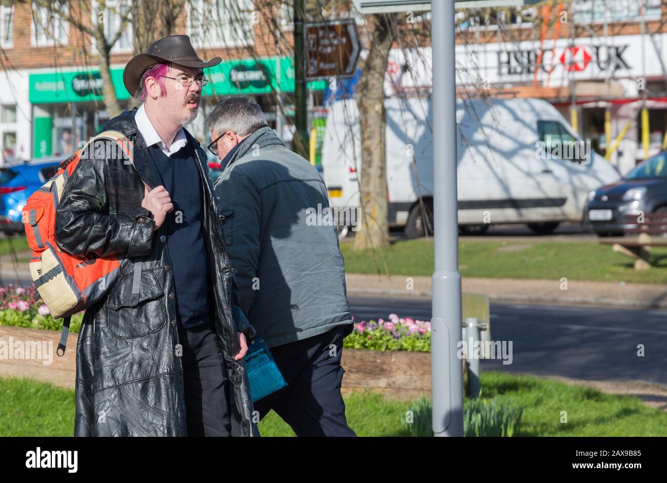 Uomo caucasico non convenzionale con capelli rosa e senso eccentrico del vestito, camminando in una strada nel Regno Unito. Foto Stock
