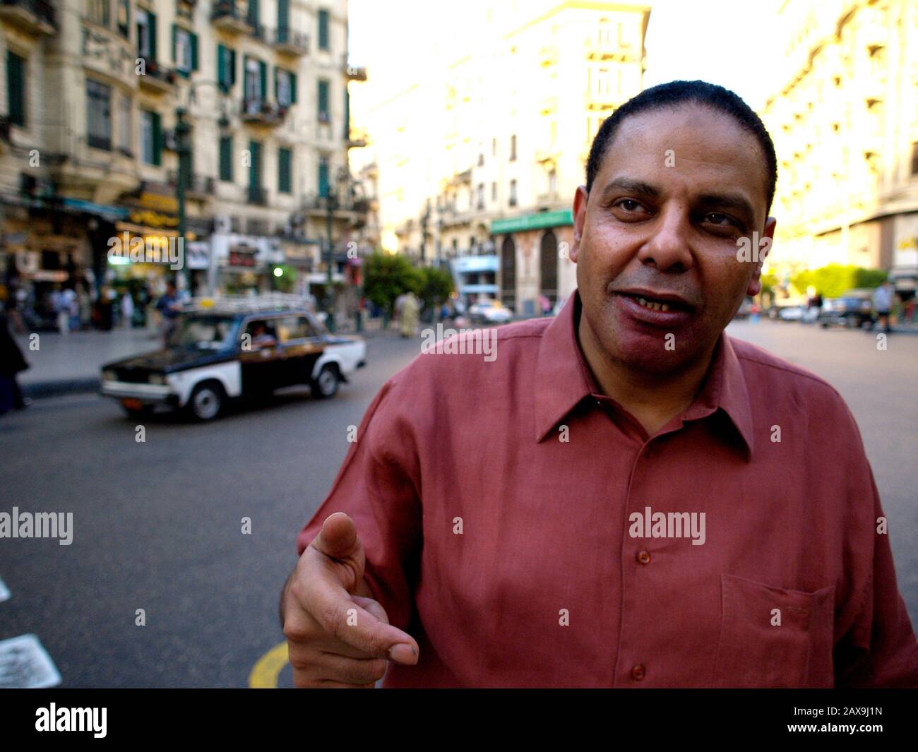 Lodato l'autore egiziano del Yacoubian Building, Alaa al Aswany, cammina lungo Suleiman Basha (Talat Haarb) strada, dove la maggior parte del suo romanzo è ambientato nel centro del Cairo venerdì 25 agosto 2006. L'edificio Yacoubian, originariamente pubblicato in arabo ma ora disponibile in inglese è un romanzo controverso che ha preso l'Egitto dalla tempesta con il suo trattamento aperto di omosessualità e le critiche del governo. Il romanzo è stato realizzato in un film che è stato rilasciato al Cairo nel luglio 2006. Aswany è considerato da molti come il nuovo Naguib Mahfouz. Foto Stock