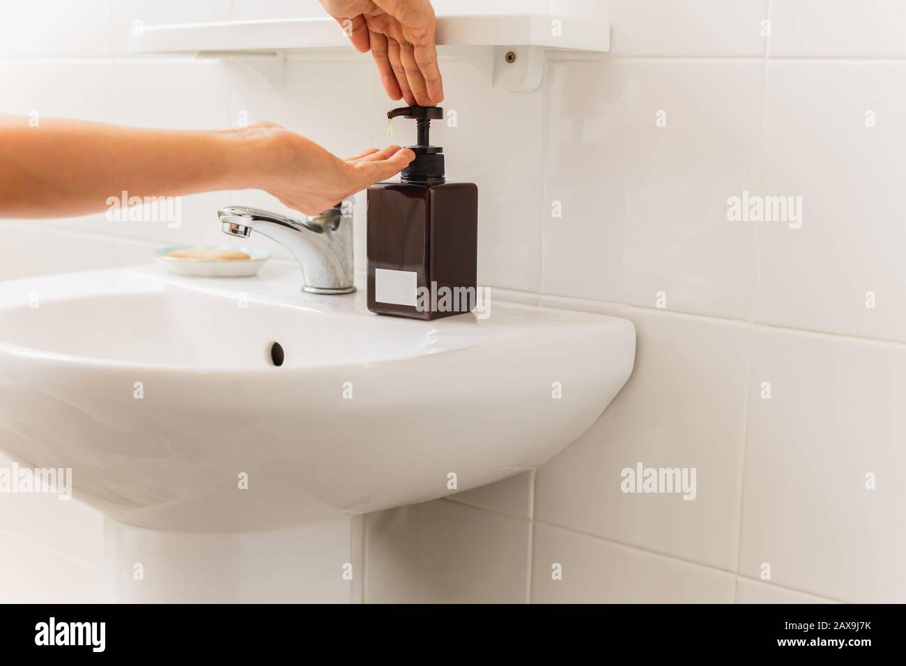 Sapone liquido per pressa a mano con pompante da bottiglia in bagno concetto di assistenza sanitaria. Foto Stock