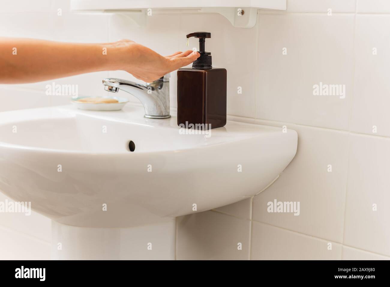 Mani con sapone liquido da bottiglia in bagno concetto di assistenza sanitaria. Foto Stock