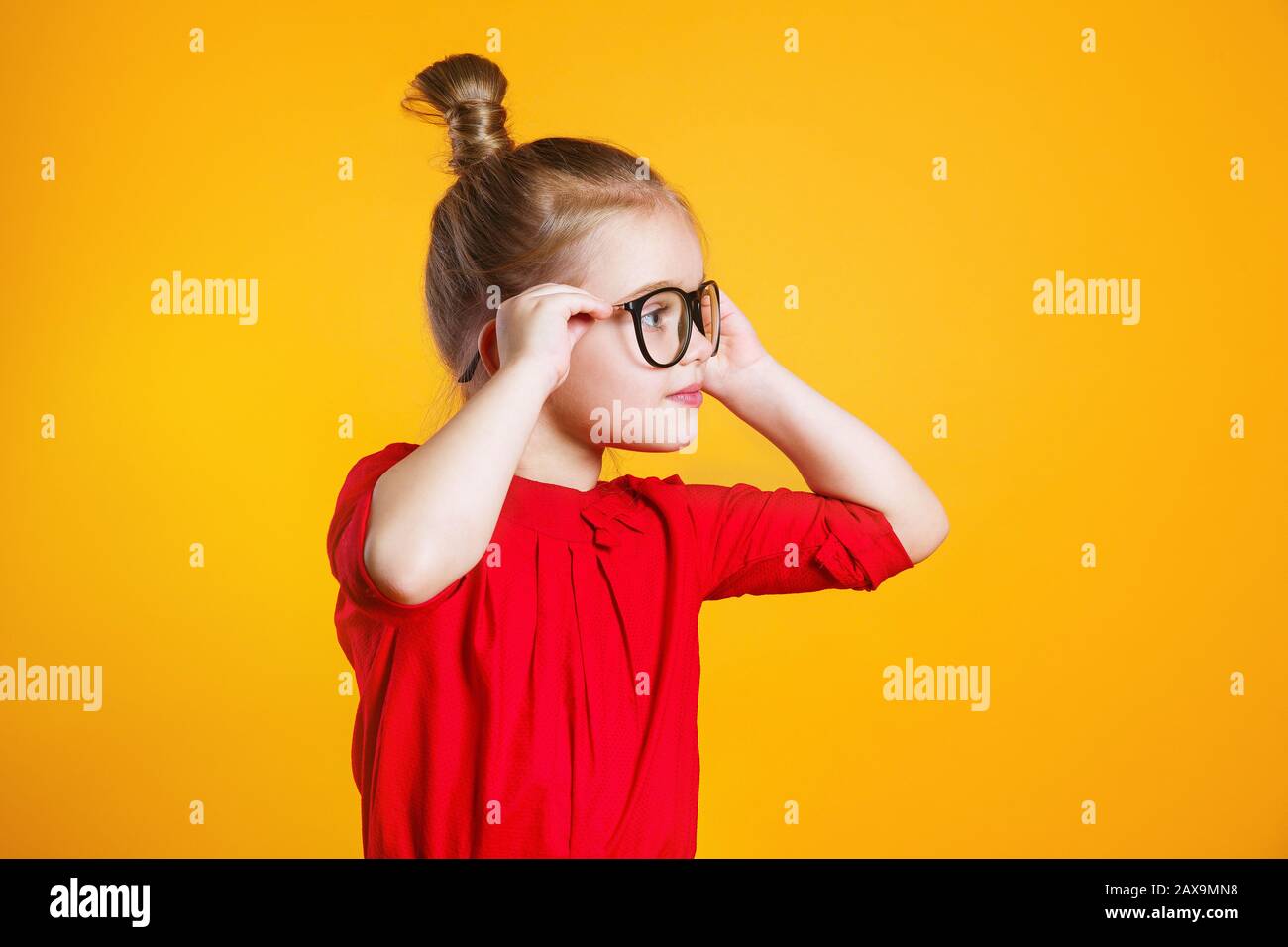 Ragazza divertente della scuola del bambino felice con gli occhiali  divertenti in aula