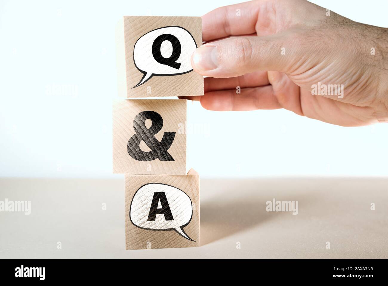 Q e un concetto di domande e risposte con bolle di parlato su blocchi di legno impilati uno sull'altro Foto Stock