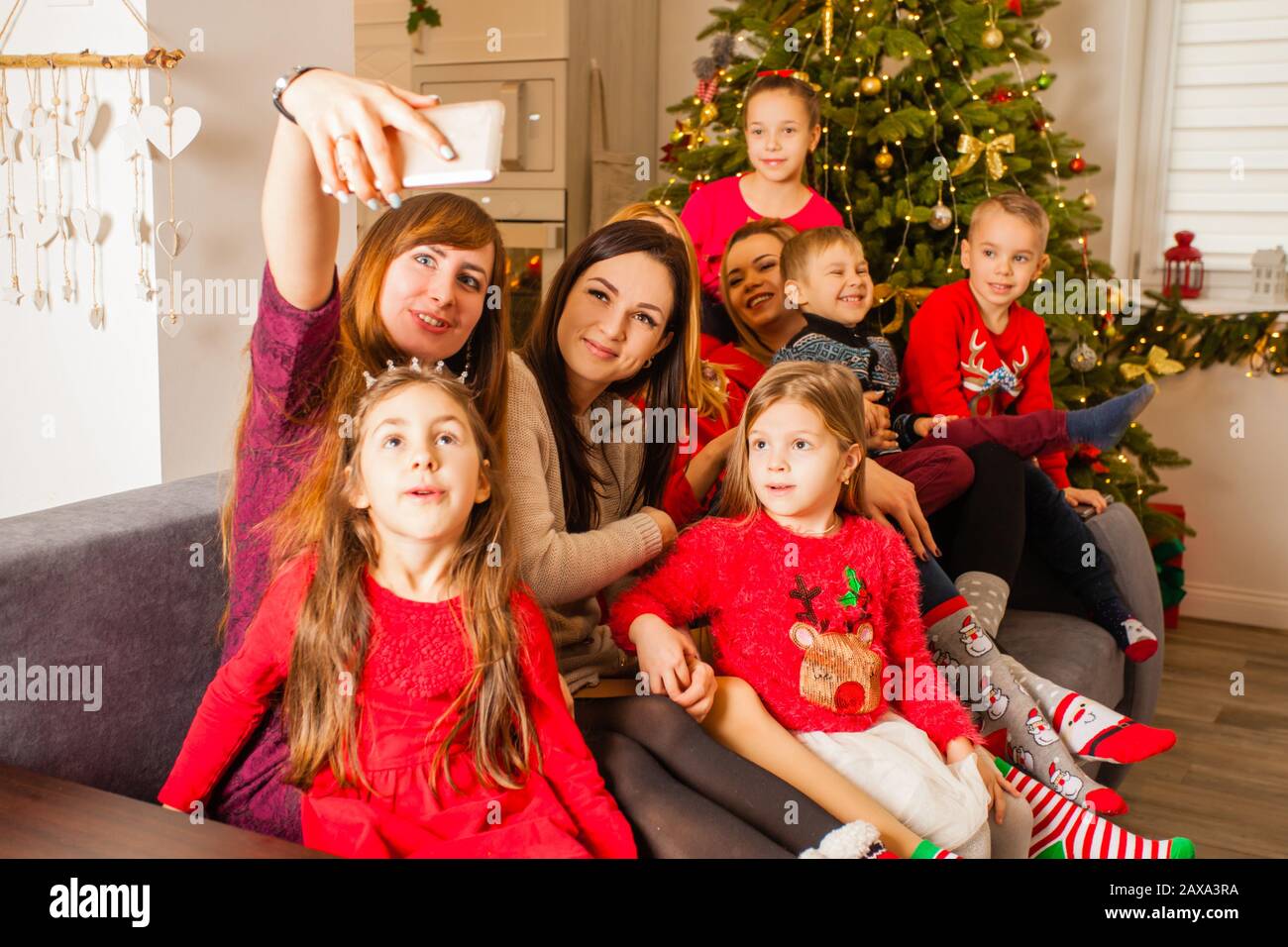 Madri e loro figli che fanno selfie sul divano Foto Stock