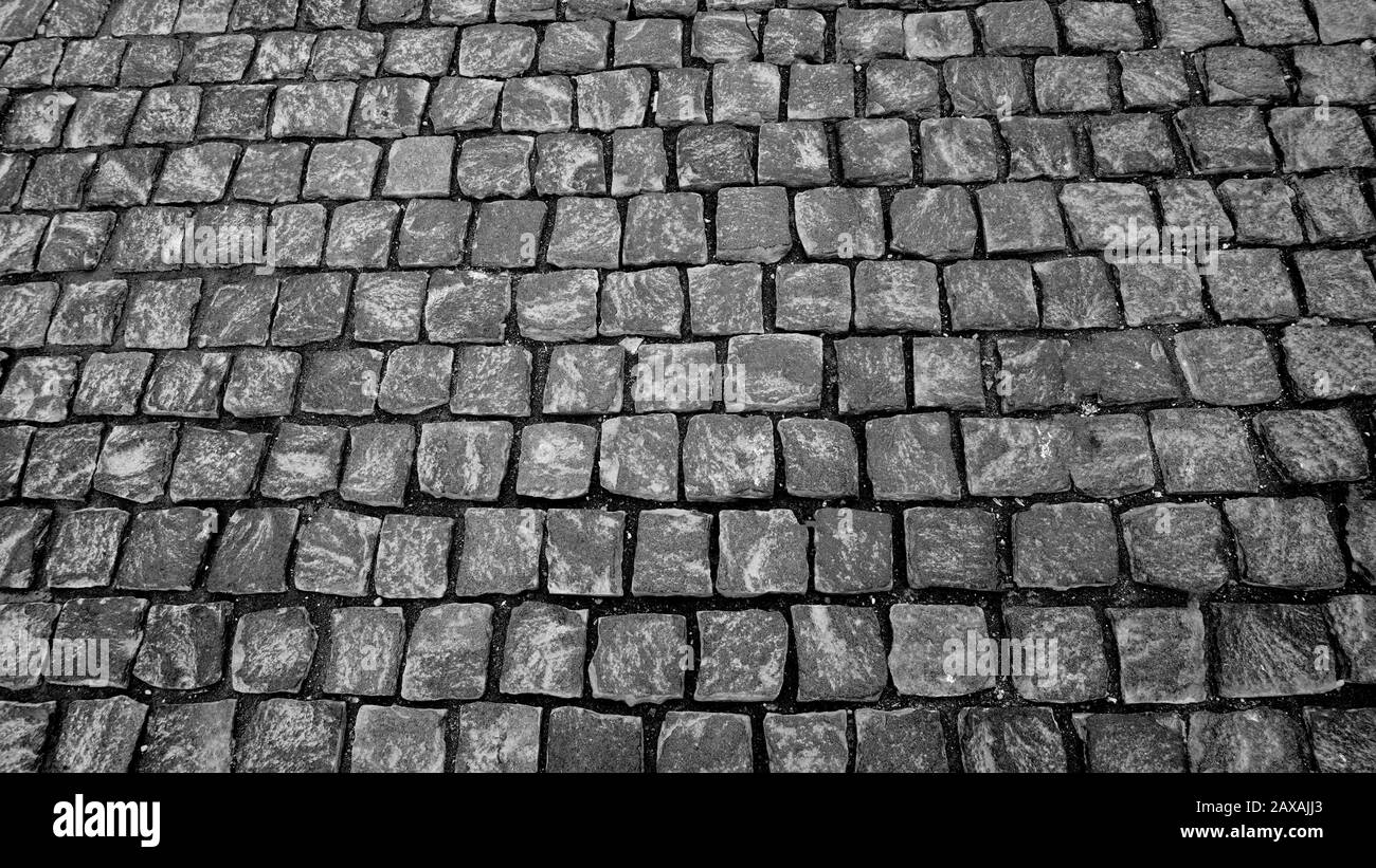 Granito lastricato marciapiede pietra cubica primo piano sfondo texture. Carta da parati Street Pavement o texture. Fotografia in bianco e nero Foto Stock