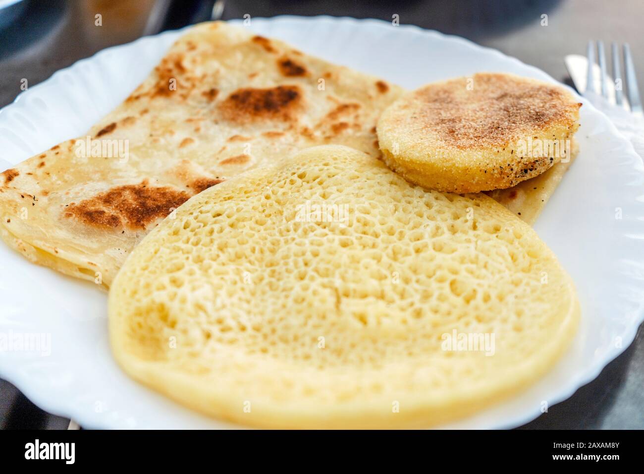 Harsha, Msemen e Beghrir serviti su piatto bianco - cibo tradizionale in Marocco Foto Stock