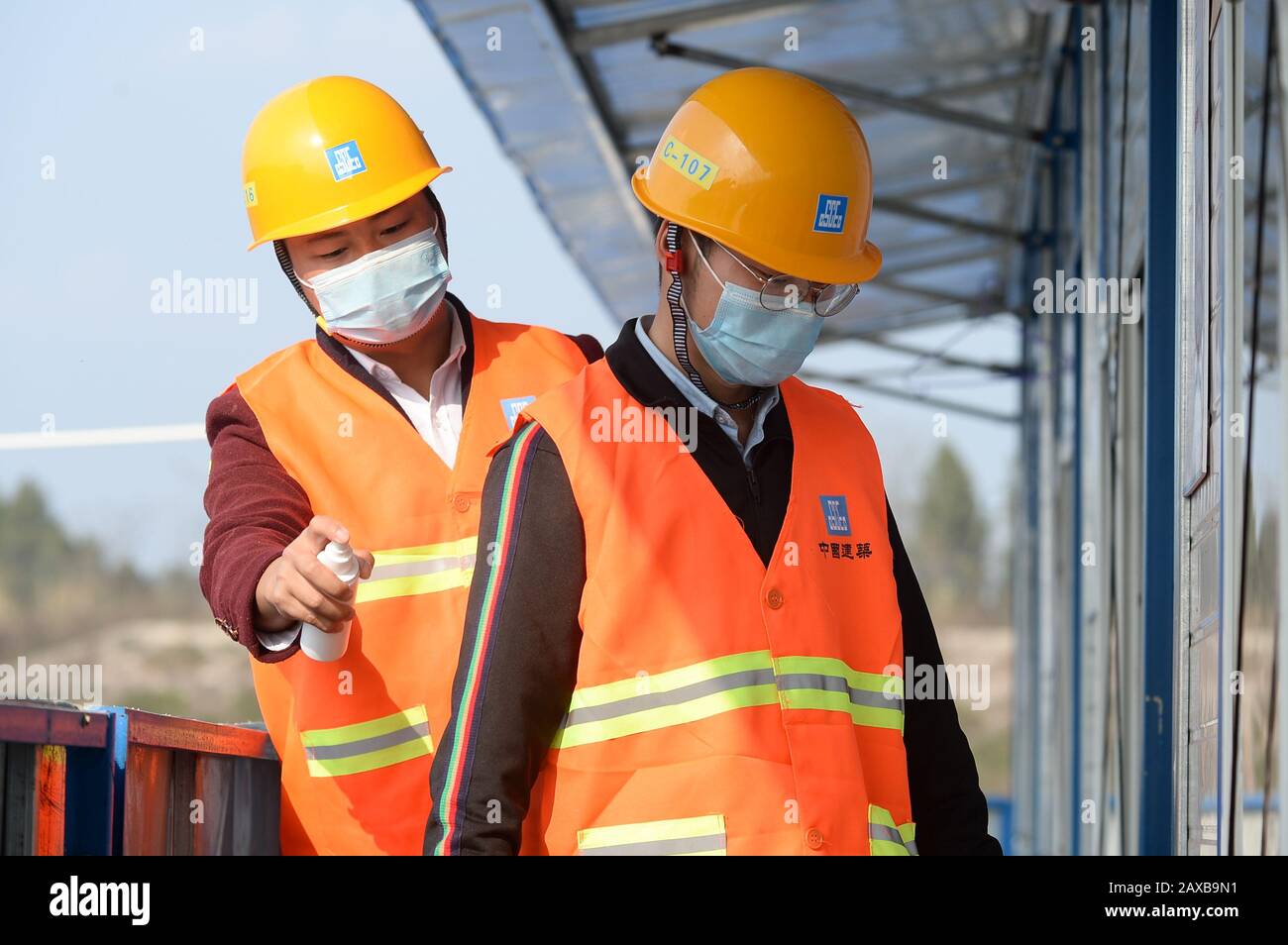 Chengdu, Cina. 11th Feb 2020. Un lavoratore aiuta a disinfettare un collega prima di entrare nel dormitorio presso il sito di costruzione dell'area ausiliaria di produzione della China Eastern Airlines (fase uno) nell'Aeroporto Internazionale di Chengdu Tianfu a Chengdu, nella provincia del Sichuan nella Cina sudoccidentale, 11 febbraio 2020. La costruzione dell'area di produzione ausiliaria della China Eastern Airlines (fase uno) nell'Aeroporto Internazionale di Chengdu Tianfu è ripresa come un sito dimostrativo di costruzione a Chengdu. Credito: Xinhua/Alamy Live News Foto Stock