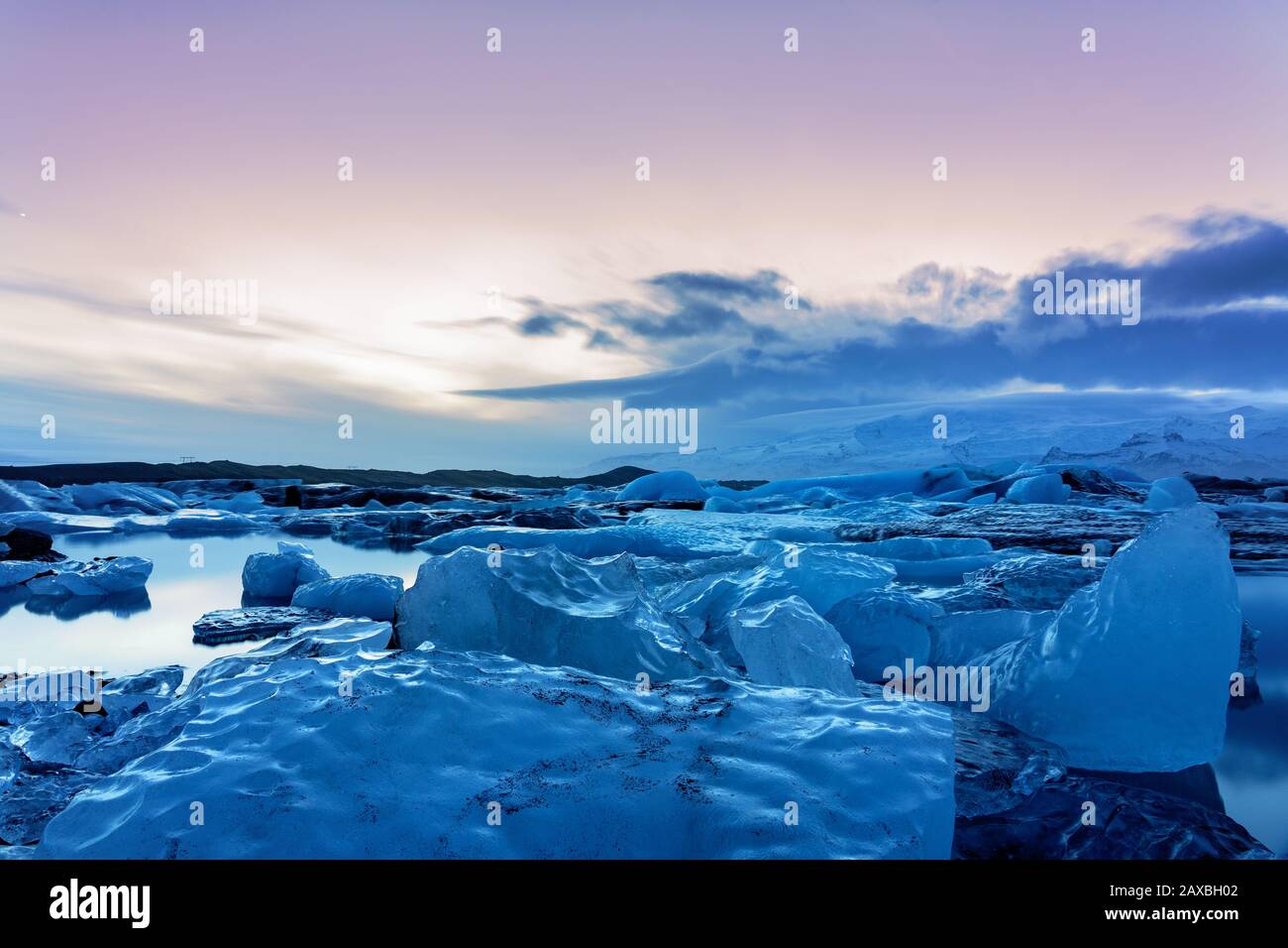 Ghiacciato ghiacciaio dell'islanda jokulsarlon negli iceberg serali che galleggiano sull'acqua fredda e tranquilla dopo il tramonto Foto Stock