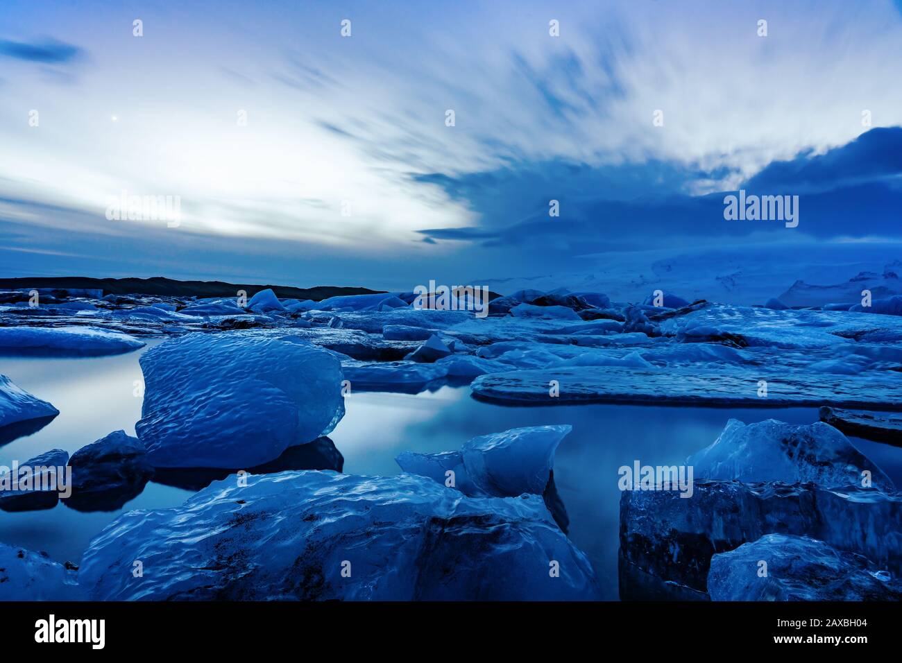 Ghiacciato ghiacciaio dell'islanda jokulsarlon negli iceberg serali che galleggiano sull'acqua fredda e tranquilla dopo il tramonto Foto Stock