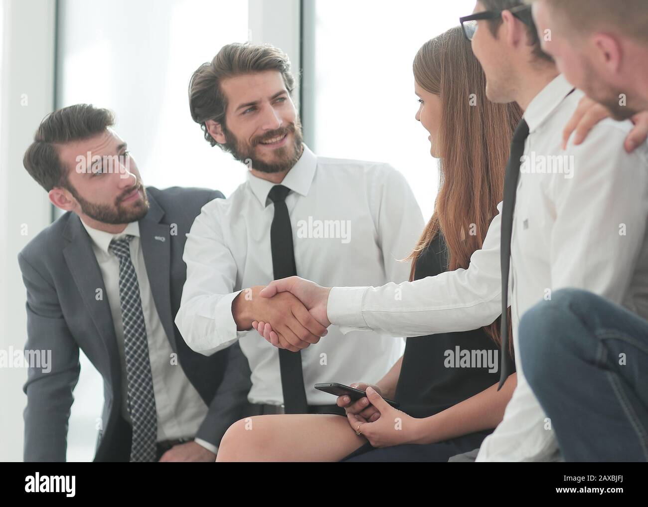 Colleghi di lavoro che stringono le mani nella lobby del centro business Foto Stock