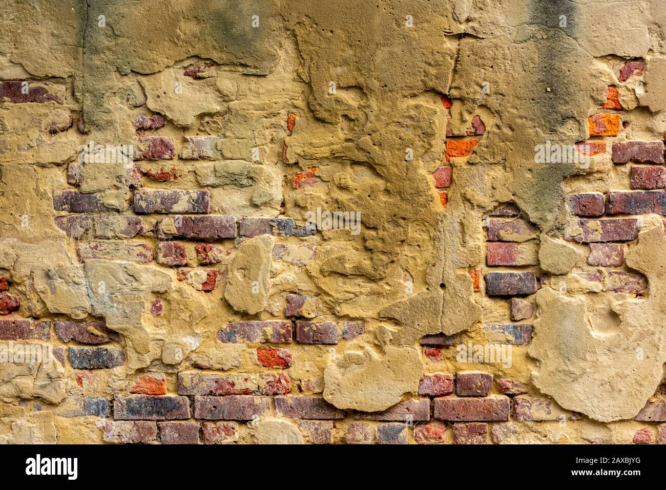 mortaio che cade da un muro di mattoni rossi in uno stato povero di riparazione e mal mantenuto edificio. Foto Stock