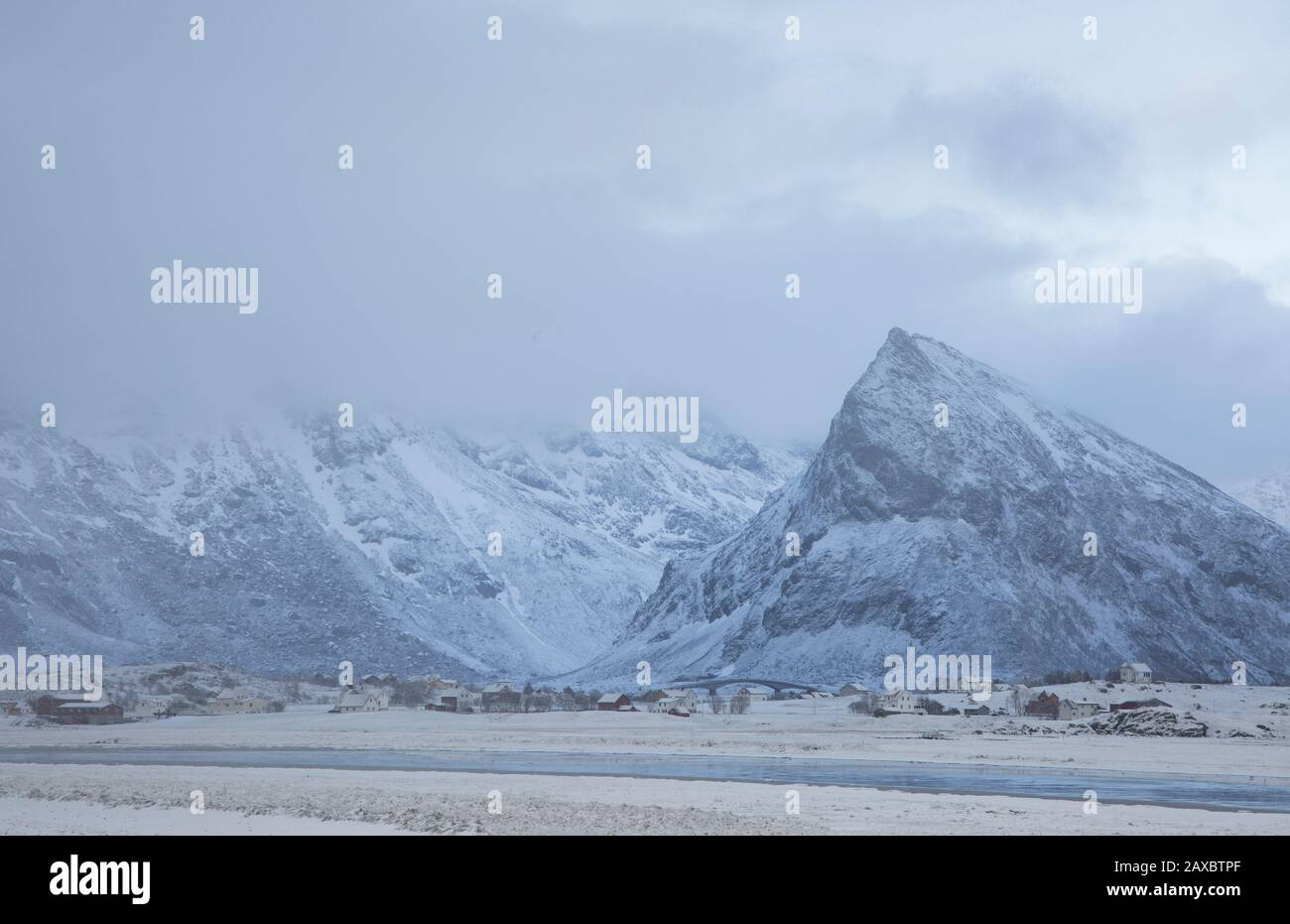 Maestose montagne innevate sopra il villaggio di Ramberg Lofoten Norvegia Foto Stock