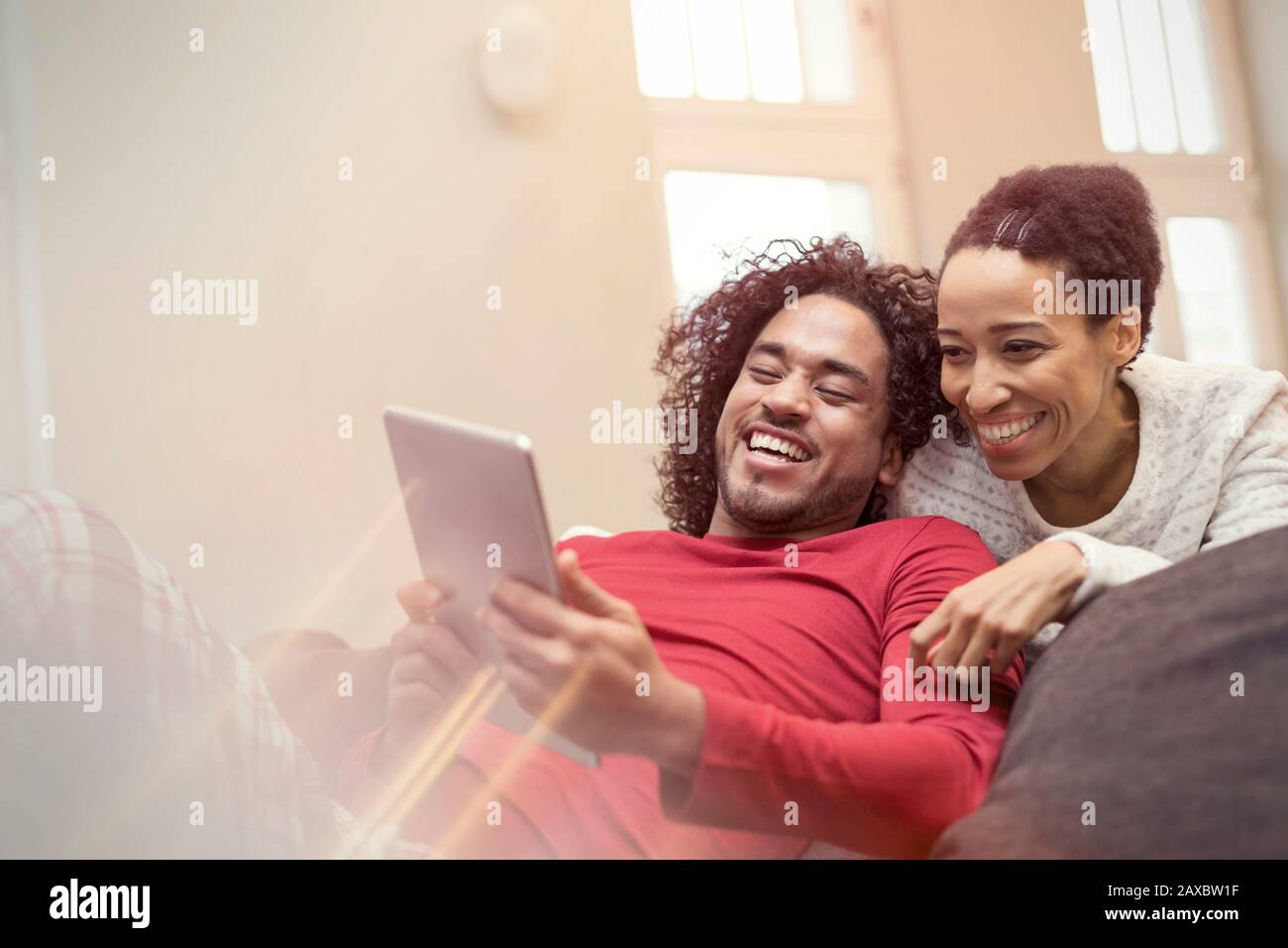 Coppia felice con tavoletta digitale sul divano Foto Stock