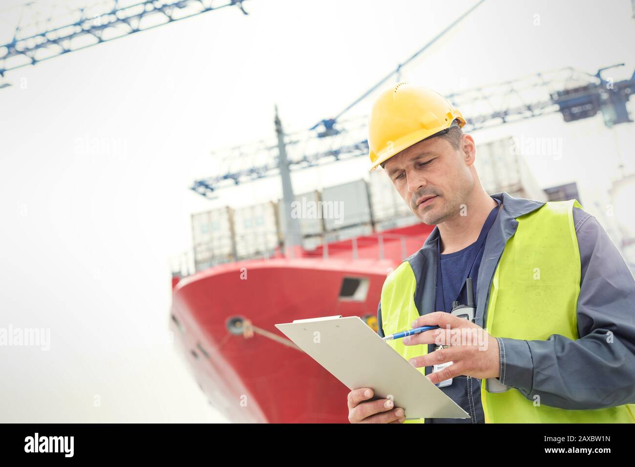 Operatore di banchina con portadocumenti sotto la nave container del cantiere navale Foto Stock