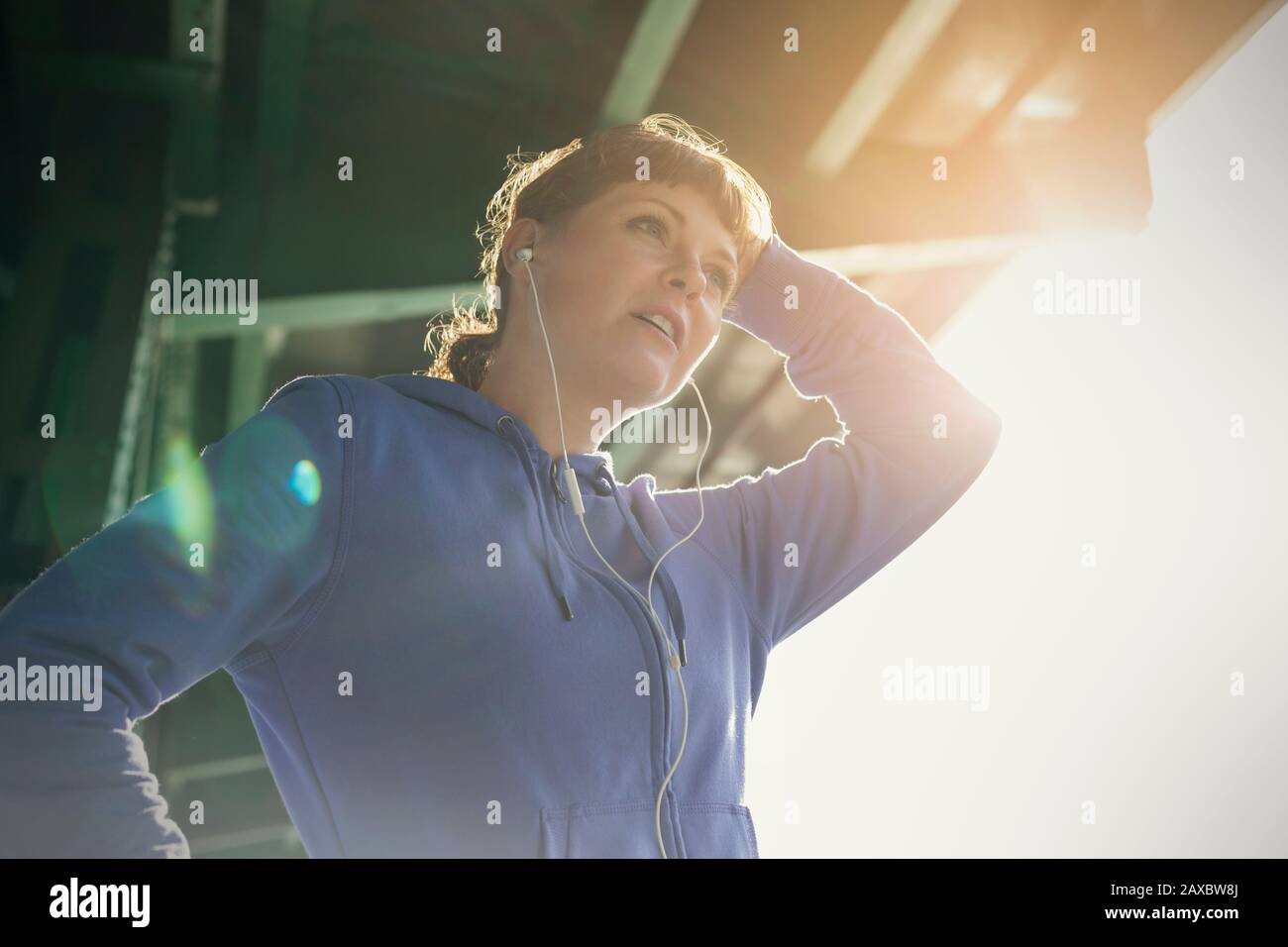Giovane corridore femminile con cuffie a riposo Foto Stock