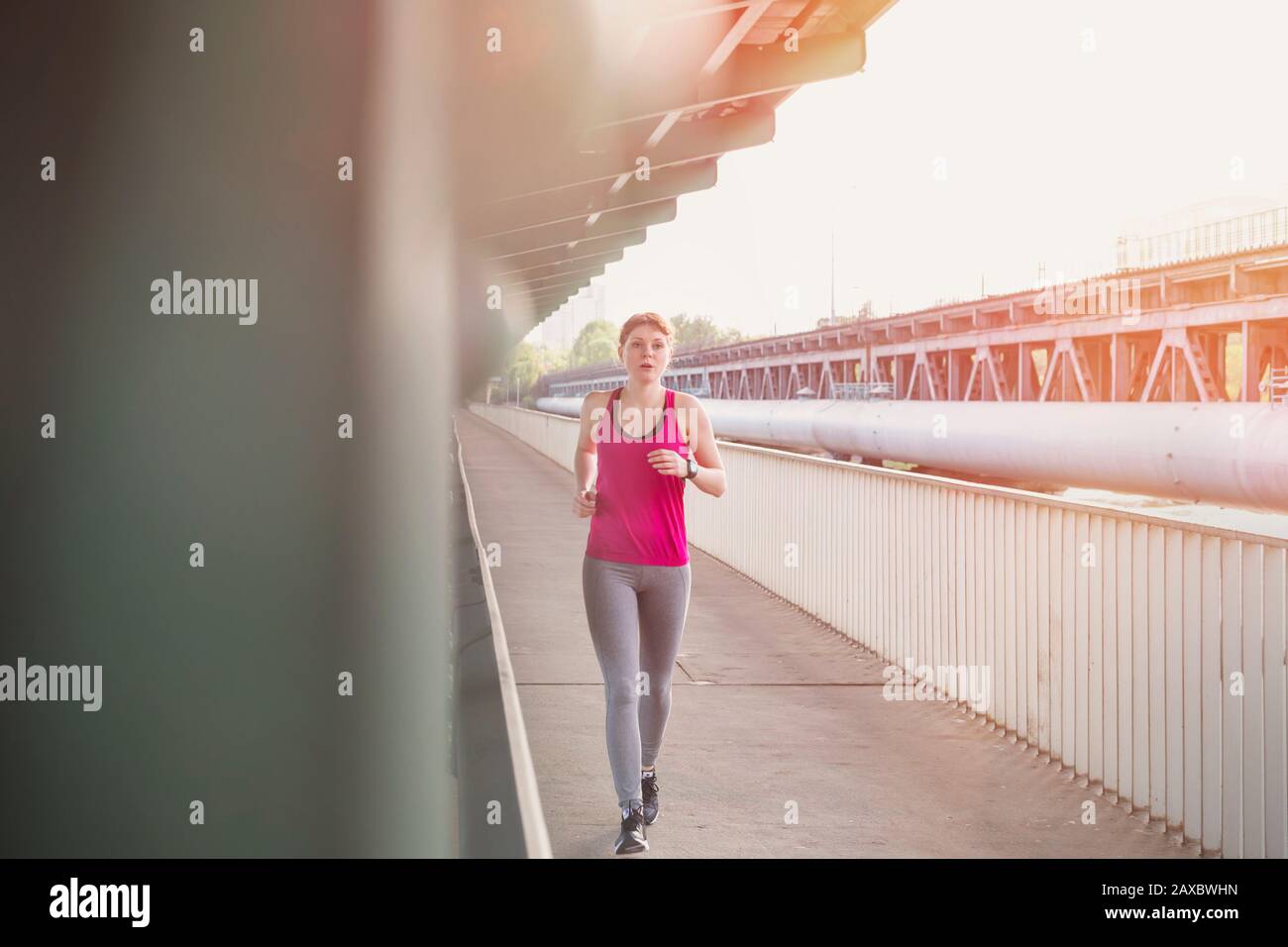 Giovane donna che corre sulla piattaforma della stazione ferroviaria urbana Foto Stock