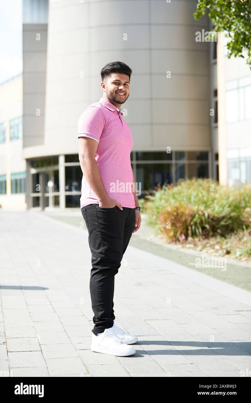 Ritratto sicuro giovane uomo fuori edificio soleggiato Foto Stock