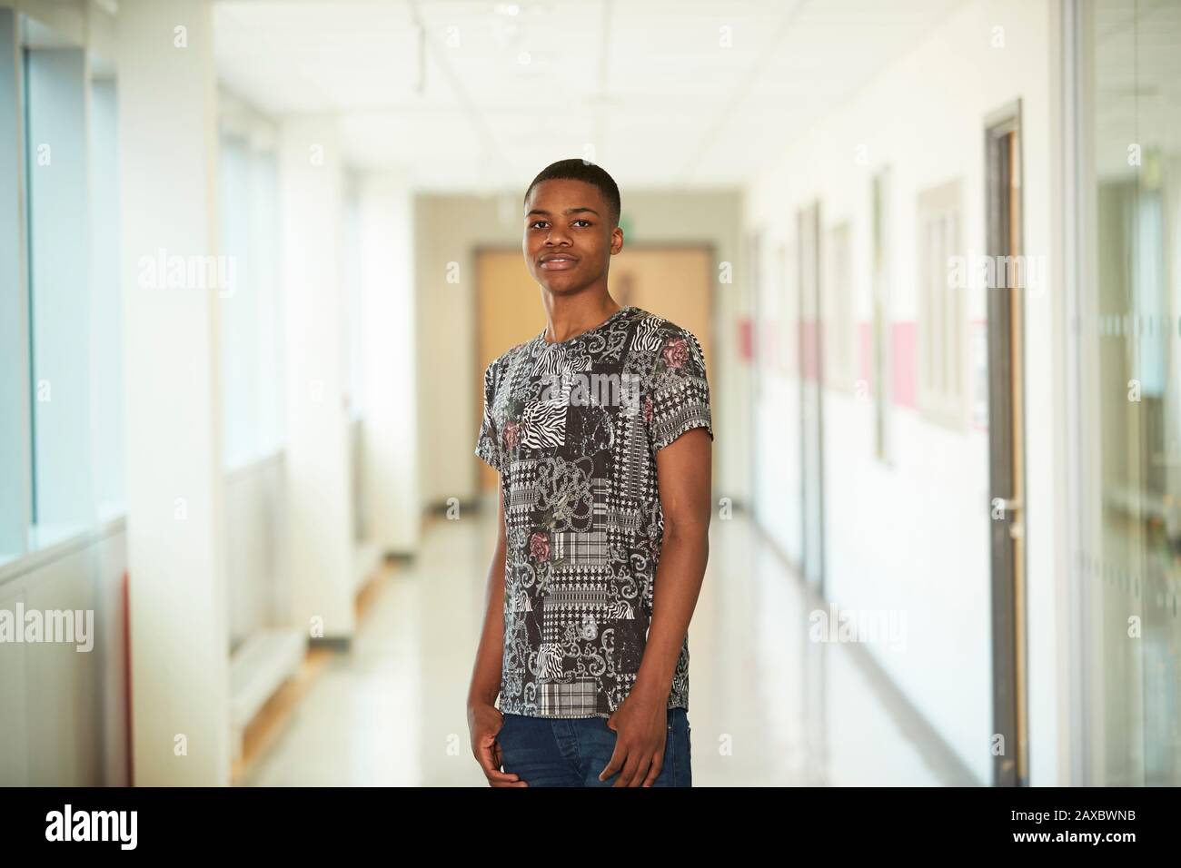 Ritratto ragazzo sicuro teenage in corridoio della scuola superiore Foto Stock